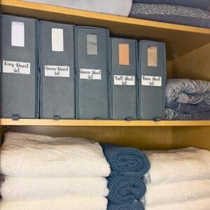 a shelf with several binders and towels